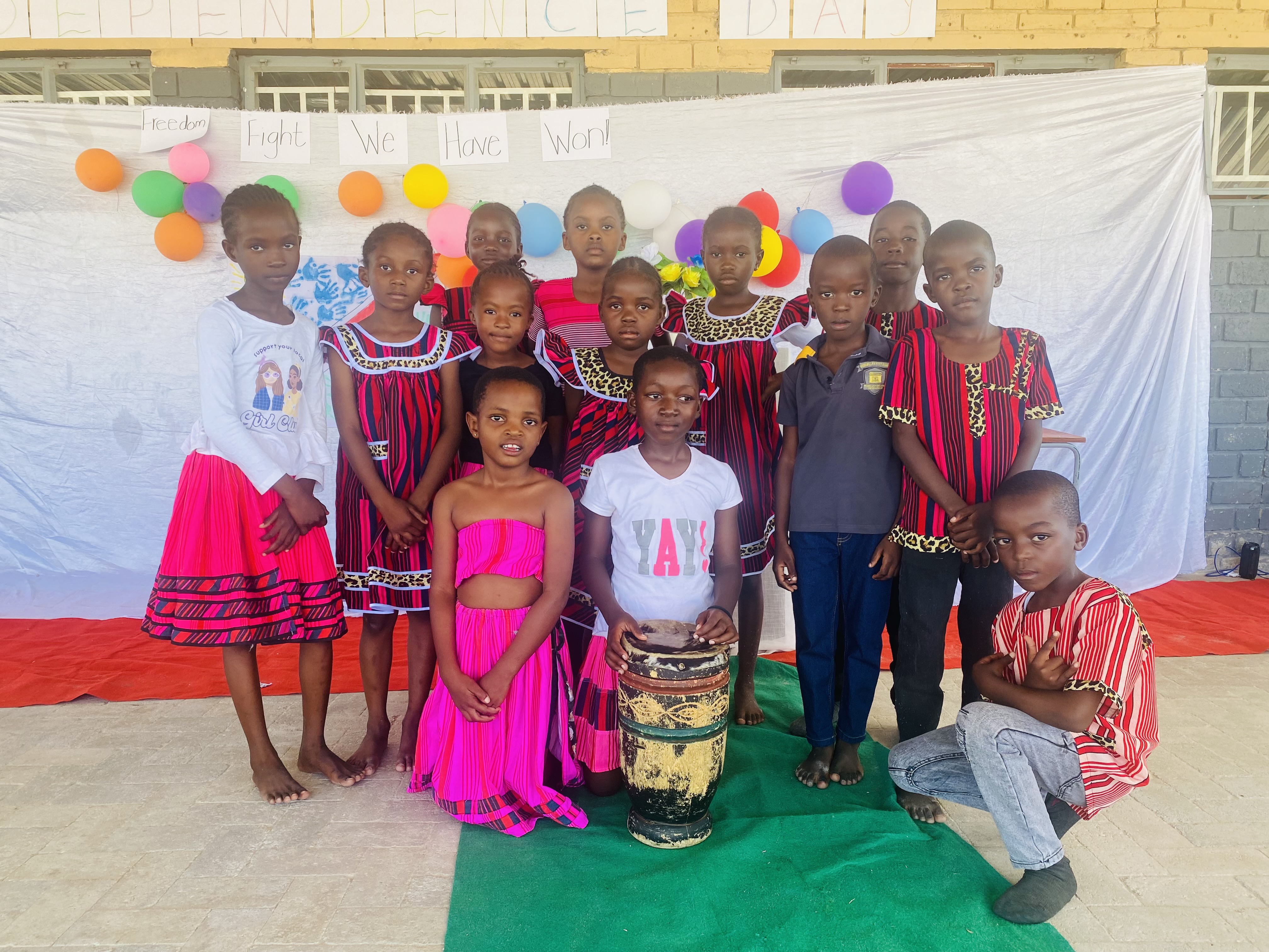 Students in traditional Namibian attire with traditional drum